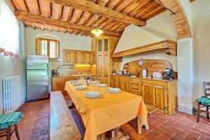 cocina con mesa larga y nevera en Casa Scopeti by PosarelliVillas, en Impruneta