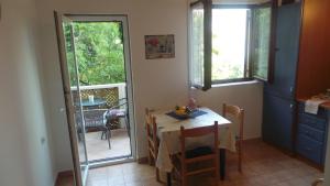 a small dining room with a table and a window at Apartments Andrea in Baška