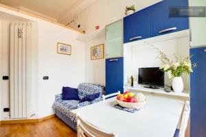 a living room with blue cabinets and a table with a bowl of fruit at Casa Vacanze Oneglia in Imperia