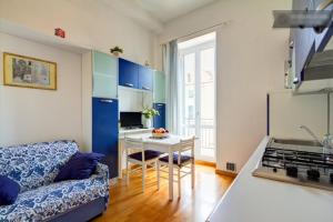 a kitchen and living room with a couch and a table at Casa Vacanze Oneglia in Imperia