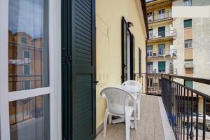 a balcony with two chairs and a table and a door at Casa Vacanze Oneglia in Imperia +3 photos