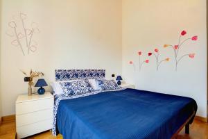 a bedroom with a blue bed with flowers on the wall at Casa Vacanze Oneglia in Imperia