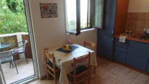 a kitchen with a table with a bowl of fruit on it at Apartments Andrea in Baška