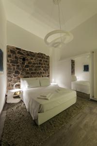 a bedroom with a large bed and a brick wall at Loft In Master Palace in Catania