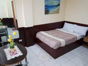 a bedroom with a bed and a table and a tableablish at City Corner Hotel in Legazpi