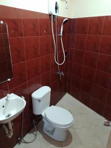 a bathroom with a toilet and a sink at City Corner Hotel in Legazpi