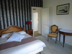 1 dormitorio con 1 cama, 1 mesa y 1 silla en Maison des Isles en Saint-Hilaire-du-Harcouët