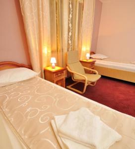 ein Schlafzimmer mit einem Bett, einem Stuhl und einem Fenster in der Unterkunft Camves Inn in Sighetu Marmaţiei