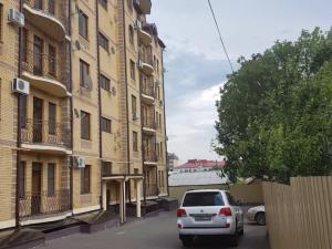 エッセントゥキにあるАпартаменты на улице Пятигорская 24, 2 этажの建物前に駐車した白車