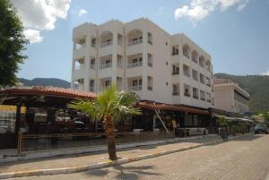 a white building with a palm tree in front of it at Diva Hotel in Marmaris