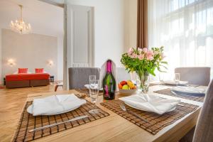 stół jadalny z butelką wina i kwiatami w obiekcie Apartments 39 Wenceslas Square w Pradze +26 zdjęć