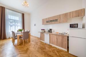 una cocina con electrodomésticos blancos y una mesa con sillas. en Apartments 39 Wenceslas Square, en Praga
