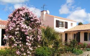 un arbusto de flores rosas delante de una casa en Chambres d'Hôtes La Forterie, en Vairé