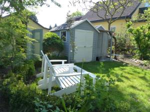 a white bench in the yard of a house at Feine Laube in Berlin