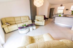 a living room with yellow couches and a kitchen at Apartment Ruby in Pula