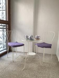 a table and two chairs with purple seats in a room at B&B Piazza Viola in Ascoli Piceno