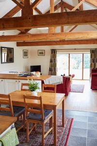 uma cozinha e sala de estar com uma mesa de madeira e cadeiras em Dallow Hall Barns em Grantley