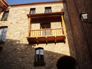 un balcón en el lateral de un edificio de piedra en El Castell de la Pobla de Lillet (Adults Only) en La Pobla de Lillet
