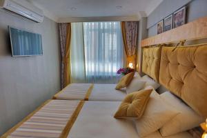 um quarto com 2 camas e uma grande janela em Just Inn Hotel em Istambul
