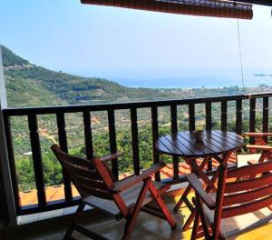 una mesa y sillas en un balcón con vistas en Agnanti Studios, en Panayia