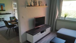a living room with a flat screen tv on a cabinet at Ferienwohnung Leer in Leer