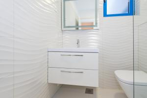 ein weißes Bad mit einem Waschbecken und einem WC in der Unterkunft Apartments & Rooms Shark in Zaboric