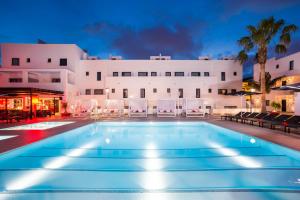 una piscina di fronte a un edificio di Migjorn Ibiza Suites & Spa a Playa d'en Bossa