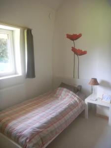 una camera da letto con un letto con un fiore rosso sul muro di Verreveld a Londerzeel
