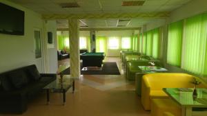 a room with couches and tables and green curtains at Pensiunea La Castel - Piscina incalzita in Costinesti