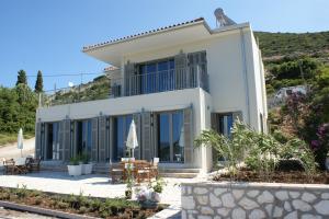 a white house with a table and chairs at Myrtos View Apartments in Anomeriá