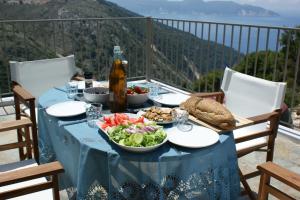 a table with a blue table cloth and a plate of food at Myrtos View Apartments in Anomeriá