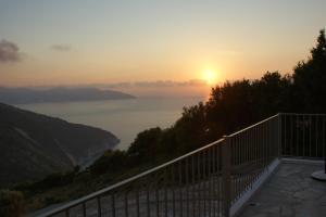 a view of the ocean at sunset from a balcony at Myrtos View Apartments in Anomeriá
