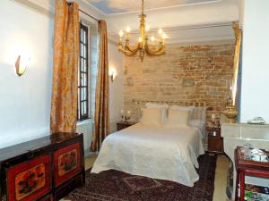 een slaapkamer met een bed en een bakstenen muur bij Maison Romane 1136 in Cluny
