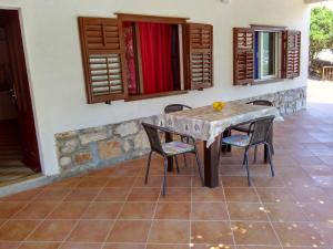 a wooden table and chairs in a room at Apartments Sonija in Gdinj