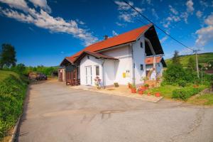 una casa blanca con techo naranja en Apartman Katja, en Rakovica