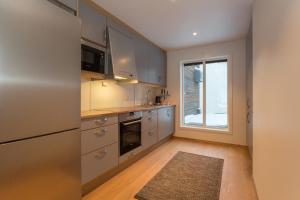 una cocina con electrodomésticos de acero inoxidable y una ventana en GLØD Boutique Apartment, en Alta