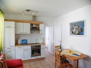 a kitchen with a table and a dining room at Ferienwohnung Amann in Nonnenhorn