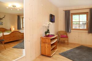 ein Schlafzimmer mit einem Bett und einem Tisch mit Blumen darauf in der Unterkunft Flatscherbauer in Lofer