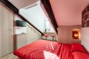 トリノにあるMultifunctional Stylish Studioのベッドルーム1室(赤いベッド1台、赤いスツール2台付)