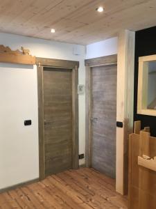 2 puertas de madera en una habitación con suelo de madera en Le samantine, en Baceno