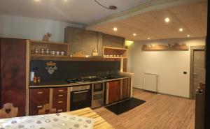 uma cozinha com armários de madeira e um forno com placa de fogão em Le samantine em Baceno