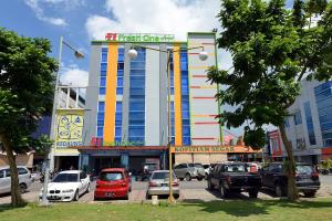 a large building with cars parked in front of it at Fresh One Hotel in Batam Center
