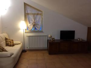 a living room with a couch and a flat screen tv at Etna View Affittacamere in Giardini Naxos