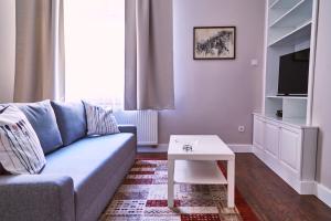 un soggiorno con divano blu e tavolo di Kraków Old Town 2 bedroom royal apartment a Cracovia