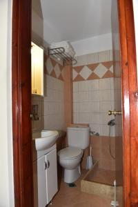 łazienka z toaletą i umywalką w obiekcie 40 Platania Hotel w mieście Loutra Edipsou