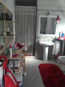 a bathroom with a sink and a toilet and a shower at Guesthouse Hygge in Tirana