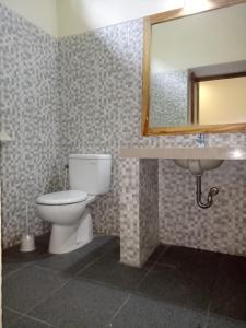 a bathroom with a toilet and a sink and a mirror at Villa Kinagu in Gili Meno