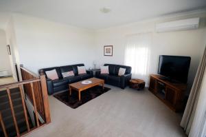 a living room filled with furniture and a tv at My Place Accommodation ALBANY in Albany