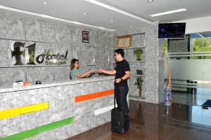 un hombre parado en un mostrador con su equipaje en Fresh One Hotel en Batam Center