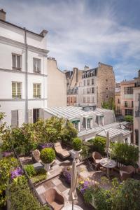 a rooftop patio with chairs and tables and buildings at Hôtel Duc De St-Simon in Paris